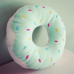 a donut shaped pillow sitting on top of a white table next to a wall