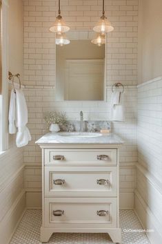 a white bathroom with two lights above the sink