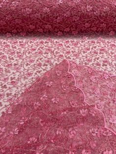 pink and white fabric with floral design on the bottom, along with other material that is not yet made