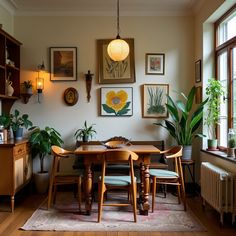 a dining room table surrounded by potted plants and pictures on the wall above it