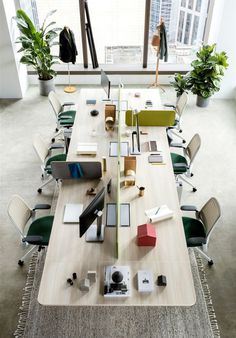 a long table with many different items on it in an office setting, including books and laptops