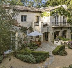 an outside view of a house with trees and bushes