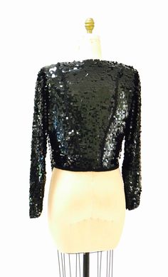 "Super Stunning sequin and beaded top She features: * Silk body fully embellished with large black sequins and beads * beautifully draped cowl neck * removable extended shoulder pads * long sleeves * Angled hem * Slip on style * Such a stunning piece! No Brand Fits like a size medium 100% silk with poly lining Great vintage condition Bust 42\" Waist 40\" Body length from Shoulder seam at back 20\" All measurements are given in full. Thank you for visiting Hooked On Honey, and remember you can ne Glamorous Sequin Tops For Winter, Contrast Sequin Long Sleeve Tops For Night Out, Long Sleeve Tops With Contrast Sequin For Night Out, Glamorous Winter Sequin Tops, Glamorous Embellished Top For Winter, Sequined Tops For Evening Winter Events, Black Party Top With Contrast Sequin, Black Party Tops With Contrast Sequin, Sequin Tops For Winter Night Out