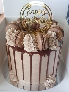 a birthday cake with chocolate frosting and flowers on top is sitting in a box