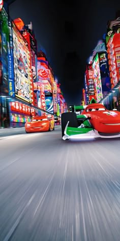 a red car driving down a street next to tall buildings with advertisements on the sides