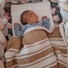 a baby is sleeping in a crocheted blanket