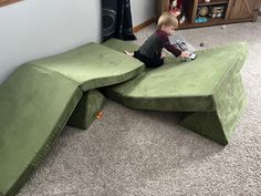 a young boy sitting on top of a green couch