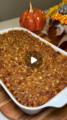 a large casserole dish filled with food on top of a wooden cutting board