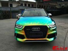 the front end of an audi car painted with holographic paint in rainbow colors