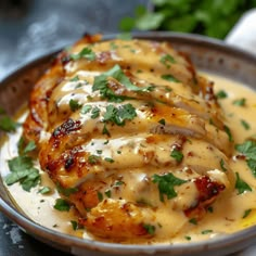 a bowl filled with chicken covered in sauce and garnished with cilantro