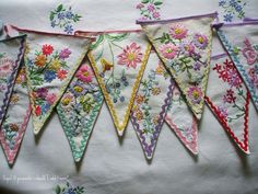 five embroidered buntings with flowers on them