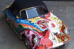 an old car painted with colorful designs on it