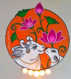 an orange plate with two white sheep on it and flowers painted on the side, surrounded by candles