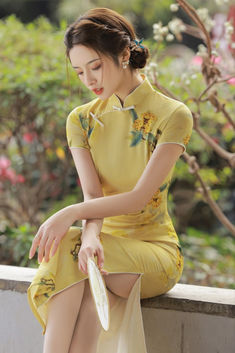 Yellow cheongsam dress with side silts, short sleeves, and a mandarin collar Traditional Fitted Floral Print Cheongsam, Traditional Fitted Floral Cheongsam, Fitted Floral Print Cheongsam With Short Sleeves, Fitted Short Sleeve Floral Cheongsam, Traditional Fitted Summer Cheongsam, Fitted Dress For Tea Ceremony, Summer Fitted Cheongsam For Tea Ceremony, Fitted Summer Cheongsam For Tea Ceremony, Fitted Cheongsam For Summer Tea Ceremony