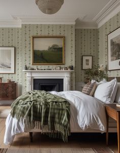 a bedroom with green and white wallpaper, a fireplace and pictures on the walls