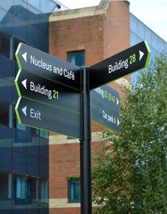 street signs pointing in different directions near a building