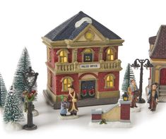 a group of figurines that are standing in front of a building with christmas decorations