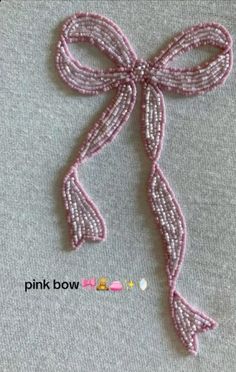 a close up of a pink ribbon on a gray surface with the words pink bow above it