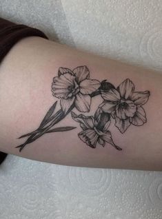 a black and white flower tattoo on the arm