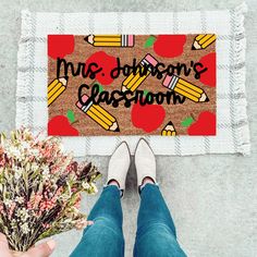 someone is holding a bouquet of flowers in front of a door mat that says,'mrs davidson's classroom '