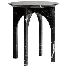 a black and white marble side table with an arched design on the top, against a white background