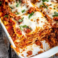 lasagna casserole with meat and cheese in a white dish on a wooden table