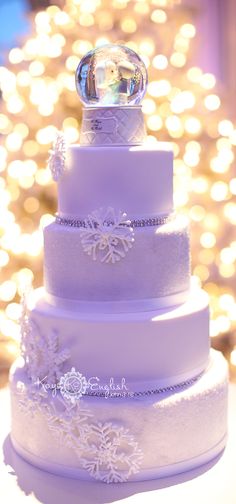 a three tiered wedding cake sitting on top of a table next to a christmas tree