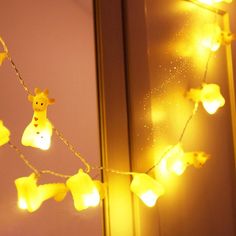 a giraffe string with lights hanging from it's sides in front of a mirror