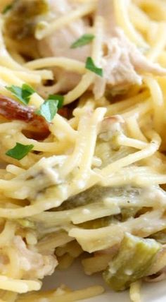 pasta with chicken, artichokes and parmesan cheese on a white plate