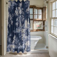 a blue and white shower curtain with flowers on it in a bathroom next to a tub