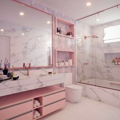 a bathroom with pink and white marble counter tops, shelving units and a large mirror above the sink