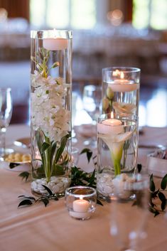 the centerpieces are filled with flowers and candles