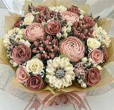 a bouquet of pink and white flowers sitting on top of a table