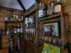 the shelves are filled with liquor bottles and other items in front of a wooden wall