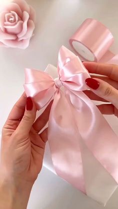 a woman's hands holding a pink ribbon