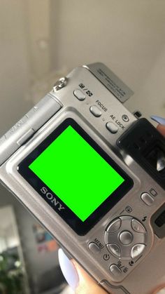 a person holding a camera with a green screen