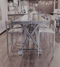 a dining room table and chairs with lights on the wall above it in an industrial style restaurant