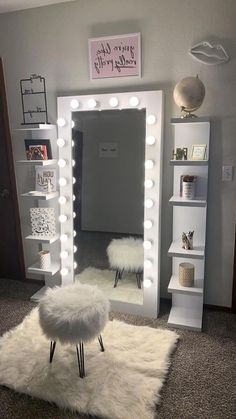 a room with a mirror, stool and lights on the wall above it in front of a bookcase