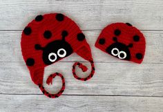 two knitted ladybug hats on top of a white wooden floor with eyes