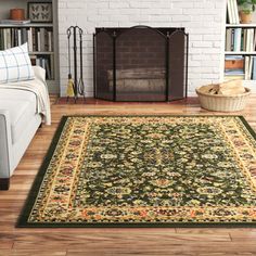 a living room with a fireplace and rugs on the floor in front of it