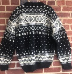 a black and white sweater hanging on a brick wall