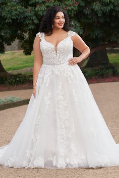 a woman in a white wedding dress posing for the camera with her hands on her hips