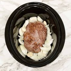 an overhead view of some food in a crock pot on a marble counter top