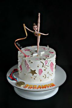 a birthday cake with a girl on top and streamers in the shape of stars