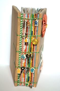 an open book with lots of different colored books on the front and sides, tied together