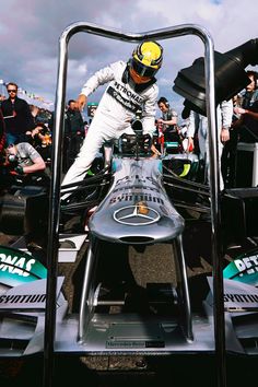 a man standing on top of a race car