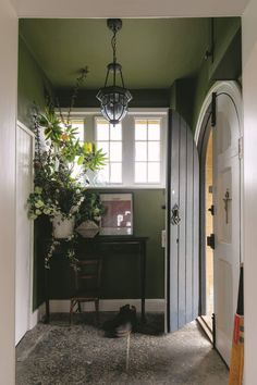 an entry way with a desk and potted plants