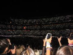 people taking pictures with their cell phones at a concert