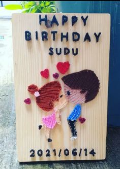 a wooden sign with two children holding each other and the words happy birthday sudu written on it