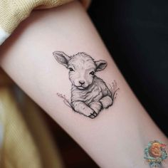 a small lamb tattoo on the arm